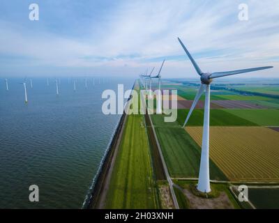 Windmühlen für die Stromproduktion Niederlande Flevoland, Windturbinen im Meer, Windmühlenfarm, der grüne Energie erzeugt. Niederlande. Stockfoto