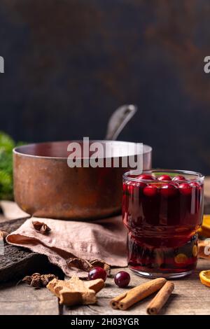 Heißer Glühwein aus Rotwein, Beeren und Orangen in einem Kupferkessel, Dekoration für Neujahr und Weihnachten Stockfoto