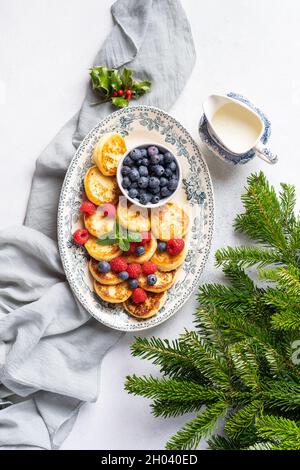 Hausgemachte Käsekuchen aus frischem Hüttenkäse zum Frühstück, Christbaumzweige Dekor Stockfoto