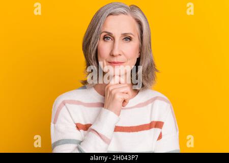 Porträt von attraktiven fokussierten grauhaarigen Frau, die Lösung Entscheidung isoliert über helle gelbe Farbe Hintergrund Stockfoto