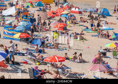 Fistral Beach in Newquay in Cornwall. Urlaubsreisende drängen sich zum Fistral Beach, um die intensive Sommersonne zu genießen. Stockfoto