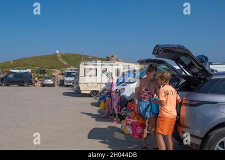 Glückliche Urlauber beanspruchen den letzten Parkplatz auf einem vollen Parkplatz in Towan Head in Newquay in Cornwall. Stockfoto