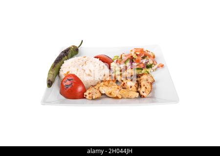 Türkischer Hähnchenspieß. Mit Gemüse, Reis in einem Porzellanservierteller auf weißem Hintergrund. Tavuk sis, Tavuk Kebap Stockfoto