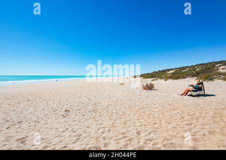 Frau, die sich am Strand sonnt, Eighty Mile Beach, Western Australia, WA, Australien Stockfoto