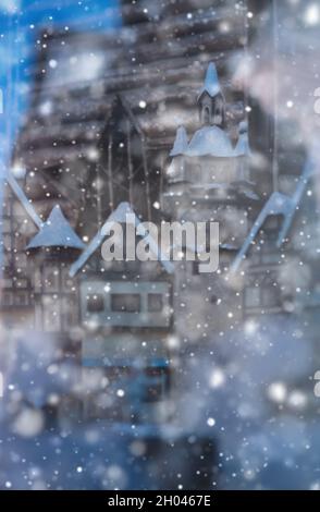 Ein gemütliches Holzhaus im Winter mit Schnee bedeckt mit den Lichtern an, Abendbild Stockfoto