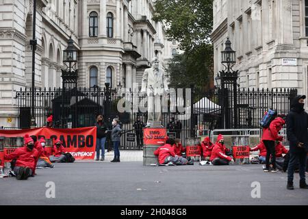 London, England, Großbritannien. Oktober 2021. Greenpeace blockiert Downing Street mit der Boris Johnson Statue, die mit Öl- und Ölfässern bedeckt ist. Die Kampagnengruppe will die Bohrungen im Ölfeld Cambo stoppen, das etwa 125 km nordwestlich der Shetland-Inseln vor dem britischen Ufer liegt. (Bild: © Tayfun Salci/ZUMA Press Wire) Stockfoto