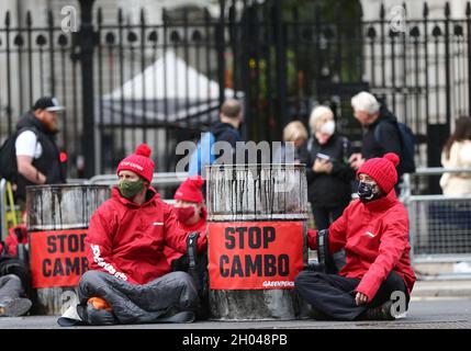 London, England, Großbritannien. Oktober 2021. Greenpeace blockiert Downing Street mit der Boris Johnson Statue, die mit Öl- und Ölfässern bedeckt ist. Die Kampagnengruppe will die Bohrungen im Ölfeld Cambo stoppen, das etwa 125 km nordwestlich der Shetland-Inseln vor dem britischen Ufer liegt. (Bild: © Tayfun Salci/ZUMA Press Wire) Stockfoto