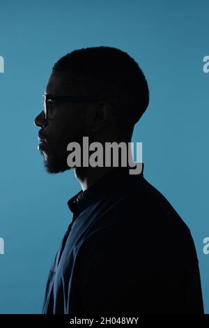 Seitenansicht Profilumriss der afroamerikanischen männlichen Silhouette vor tiefblauem Hintergrund Stockfoto