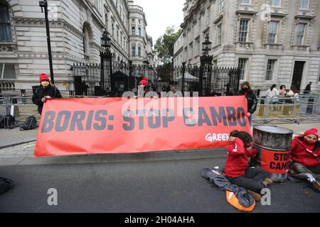 London, England, Großbritannien. Oktober 2021. Greenpeace blockiert Downing Street mit der Boris Johnson Statue, die mit Öl- und Ölfässern bedeckt ist. Die Kampagnengruppe will die Bohrungen im Ölfeld Cambo stoppen, das etwa 125 km nordwestlich der Shetland-Inseln vor dem britischen Ufer liegt. (Bild: © Tayfun Salci/ZUMA Press Wire) Stockfoto