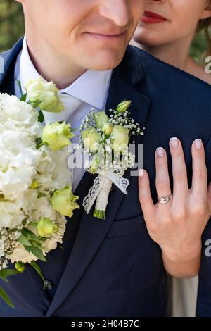 Nahaufnahme von Brautpaten, die sich gegenseitig umarmen. Gerade verheiratet Mann und Frau aus der Nähe. Hochzeit und Liebe Konzept. Stockfoto