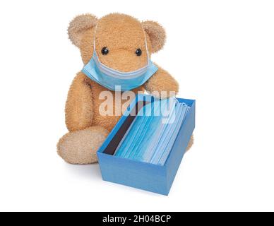 Teddybär weiches Spielzeug hält eine Schachtel mit medizinischen Masken. Stockfoto