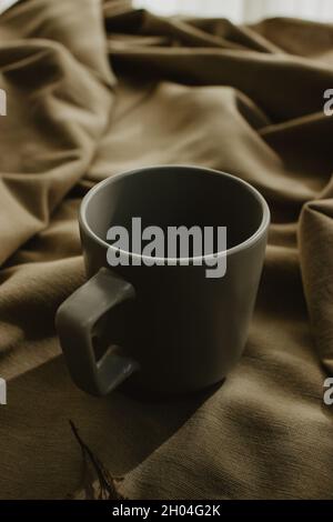 Leere graue Kaffeetasse auf beigem Hintergrund isoliert. Nahaufnahme. Konzept des Kaffees. Stockfoto