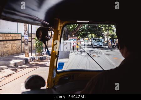 Bangalore, Indien - 08. Juni 2020. Rikscha fährt durch die Straßen von Bengaluru Indien. Blick aus dem Inneren des Tuk Tuk. Fahrer Taxi und Bürger Stockfoto