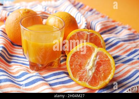 Orangensaft im Glas auf farbigem Hintergrund Stockfoto