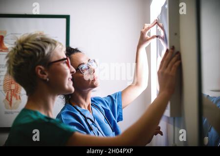 Nahaufnahme von zwei Ärzten, die Röntgenbilder von Knochenbrüchen beobachten. Stockfoto