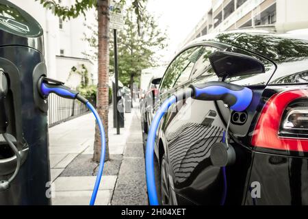 Elektroauto eingesteckt und umgezogen auf der Stadtstraße Stockfoto