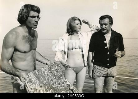 Die italienischen Schauspieler Ugo Tognazzi (rechts), Luc Merenda und Edwige Fennech am Strand, Italien der 1970er Jahre Stockfoto