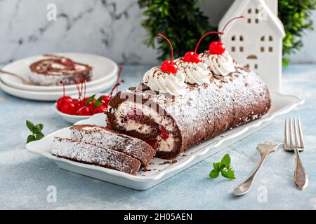 Schwarze Waldkuchenrolle mit Schlagsahne und Kirschen, Nachtisch zu Weihnachten Stockfoto
