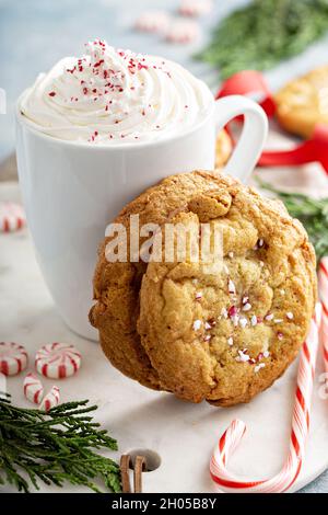 Pfefferminzbonblätzchen aus weißer Schokolade, frisch zu Weihnachten gebacken, serviert mit heißer Schokolade Stockfoto