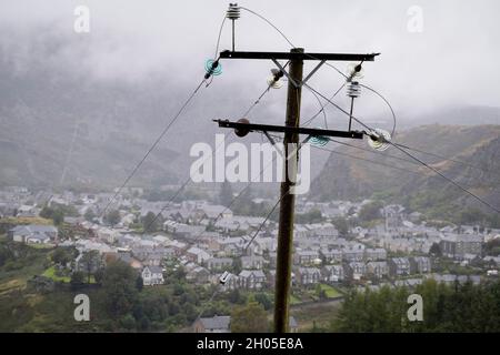 Über der walisischen Stadt Blaenau Ffestiniog stehen am 2. Oktober 2021 ein Strommast und Leiter in Blaenau Ffestiniog, Gwynedd, Wales. (Die vollständige Bildunterschrift über die Schieferindustrie finden Sie hier in der Beschreibung). Stockfoto