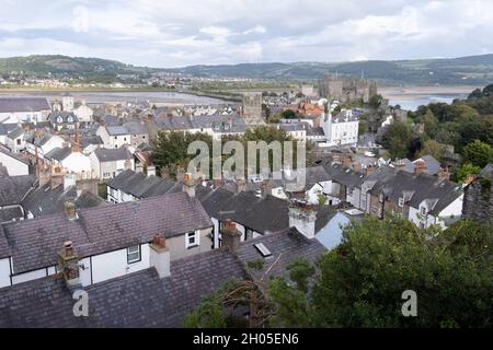 Von den Wällen der mittelalterlichen Burg von Conwy aus gesehen, befinden sich die Dächer der Häuser in den befestigten Mauern am 4. Oktober 2021 in Conwy, Gwynedd, Wales. Die Mauern wurden zwischen 1283 und 1287 nach der Gründung von Conwy durch Edward I. errichtet und sollten neben Conwy Castle ein integriertes Verteidigungssystem bilden. Die Mauern sind 1.3 km (0.81 mi) lang und umfassen 21 Türme und drei Torhäuser. Conwy ist eine ummauerte Marktstadt und Gemeinde an der Nordküste von Wales. Stockfoto