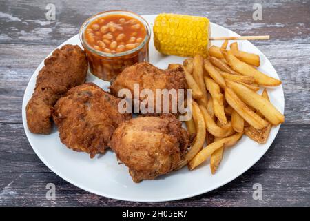 Gebratenes Huhn mit Pommes Frites, gebackene Bohnen und Süßmais Abendessen Stockfoto