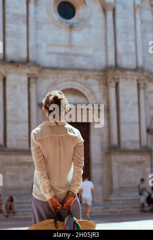 Reisen Sie in Italien. Von hinten gesehen eine moderne Reisende Frau mittleren Alters in der Toskana, Italien, die die Promenade in der Nähe der Kathedrale in Pienza genießt. Stockfoto