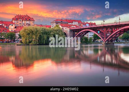 Maribor, Slowenien. Stadtbild von Maribor, Slowenien bei schönem Sommeruntergang mit Spiegelung der Stadt in der Drau. Stockfoto