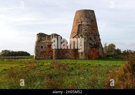 Blick auf das zerstörte Torhaus und die Entwässerungsmühle der Abtei St. Benet auf den Norfolk Broads in der Nähe von Horning, Norfolk, England, Großbritannien. Stockfoto