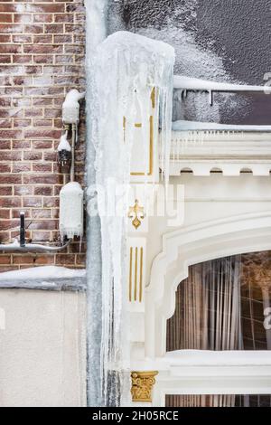 Große hängende Eiszapfen an einem historischen Haus während eines kalten Winters im niederländischen Stadtzentrum von Doesburg, Niederlande Stockfoto