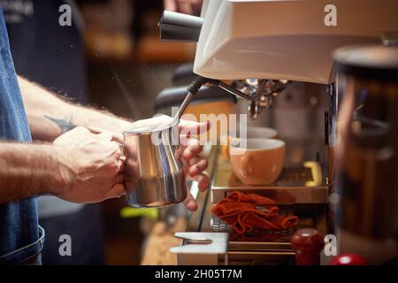 Nahaufnahme eines Mitarbeiters, der Kaffee auf der Espressomaschine zubereitet Stockfoto