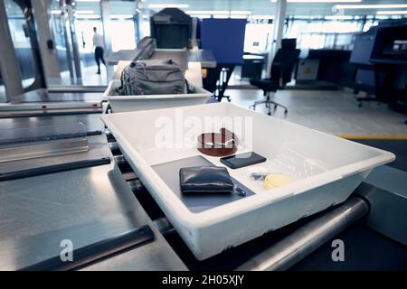 Persönliche Gegenstände, Flüssigkeiten und Laptop im Container bei der Sicherheitskontrolle des Flughafens vor dem Flug. Stockfoto