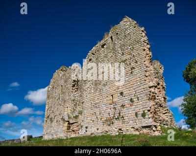 Die Südwestwand des zerstörten Thirlwell Castle in Northumberland, England, Großbritannien. Aufgenommen an einem sonnigen Tag mit blauem Himmel. Stockfoto