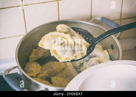 Kochen Sie frische Knödel gefüllt mit Sauerkirsche mit Zucker Stockfoto