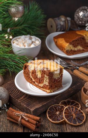 Zebra-Schokoladenkuchen auf weihnachtlichem Hintergrund. Seitenansicht, vertikal. Stockfoto