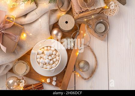 Kaffee und Weihnachtsdekorationen im Licht der Weihnachtsbeleuchtung. Stockfoto