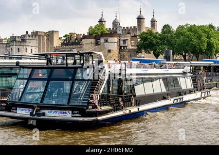 Ein City Cruises River Tour Boot mit dem Tower of London im Hintergrund, London, Großbritannien. Stockfoto