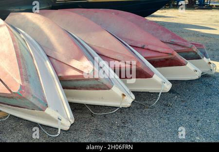 Ende der Bootssaison - Ruderboote mit rotem Grund werden geordnet aufeinander gestapelt. Nahaufnahme Stockfoto