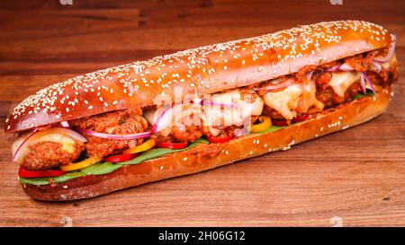 Nahaufnahme eines barbari-Brotes mit einem fußlangen Fleischball auf einer braunen Holzoberfläche Stockfoto