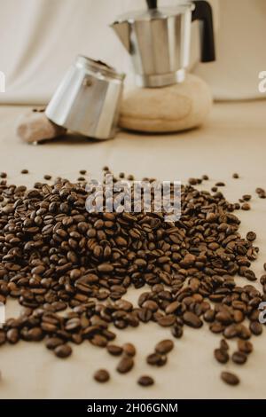 Set von Kaffeebohnen in Hintergrund Kaffeekocher auf einem braunen Hintergrund. Stillleben-Kaffeefotografie. Stockfoto