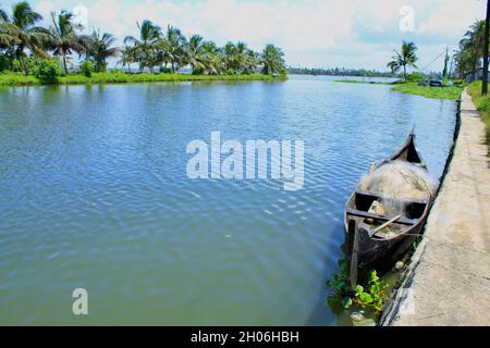 Blick vom Pony eines Flusses mit einem kleinen Fischerboot im Vordergrund Stockfoto