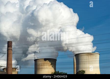 Weiße Wolken aus Wasserdampf, die aus dem Kühlturm einer Stromerzeugungsanlage hervorgehen. Stockfoto