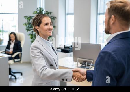 Zwei erfolgreiche Kollegen im formalwear Handshaking im Büro nach Vertragsunterzeichnung Stockfoto