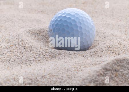 Golfball im Sandbunker geringe Schärfentiefe hautnah. Stockfoto