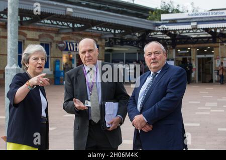 Maidenhead, Großbritannien. Oktober 2021. Theresa May, konservative Abgeordnete von Maidenhead, spricht anlässlich der offiziellen Eröffnung eines neuen Bahnhofsvorplatzes mit Cllr Gerry Clark (c), dem Royal Borough of Windsor und dem Kabinettsmitglied von Maidenhead für Verkehr und Infrastruktur, und Bob Beveridge (r), Vorsitzender des Berkshire LEP im Thames Valley. Die 3,75 Mio. £große Sanierung soll das Bahnhofsgebiet vor der Eröffnung der Crossrail-Strecke verkehrsfreundlicher machen und sowohl den Austausch zwischen Zügen und anderen Verkehrsmitteln als auch das Gehen und Gehen verbessern Stockfoto