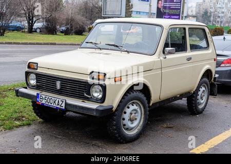 Bukarest, Rumänien, 4. Januar 2021 das alte weiße Lada Niva Auto aus Russland parkte an einem sonnigen Wintertag auf einer Straße Stockfoto
