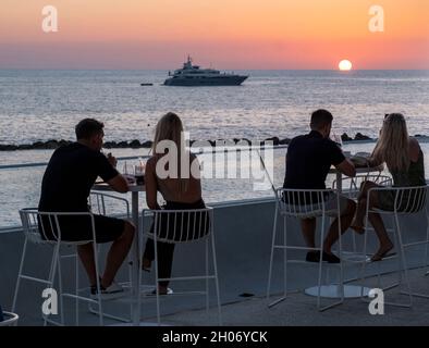 Kunden beobachten den Sonnenuntergang vom Antasia Beach Club, SODAP Beach, Paphos, Zypern Stockfoto