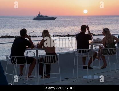 Kunden beobachten den Sonnenuntergang vom Antasia Beach Club, SODAP Beach, Paphos, Zypern Stockfoto