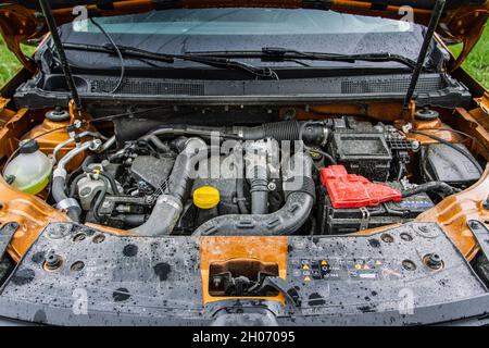 SUV-Wagen mit offener Haube. Automotor. Automotor und Teile unter der Motorhaube Stockfoto