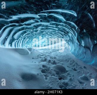 Blauer Kristall-Eishöhleneingang und ein unterirdischer Fluss unter dem Gletscher in den Highlands in Island Stockfoto